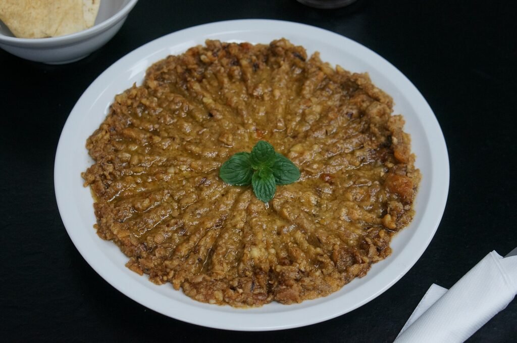 Le koshari avec sa sauce et ses oignons frits, et une assiette de foul medammes.